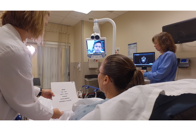 A picture of a woman in the hospital getting tested by physician via telehealth.